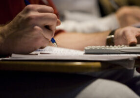 student writing on paper