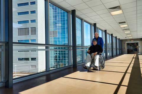 Man wheeling in a patient.